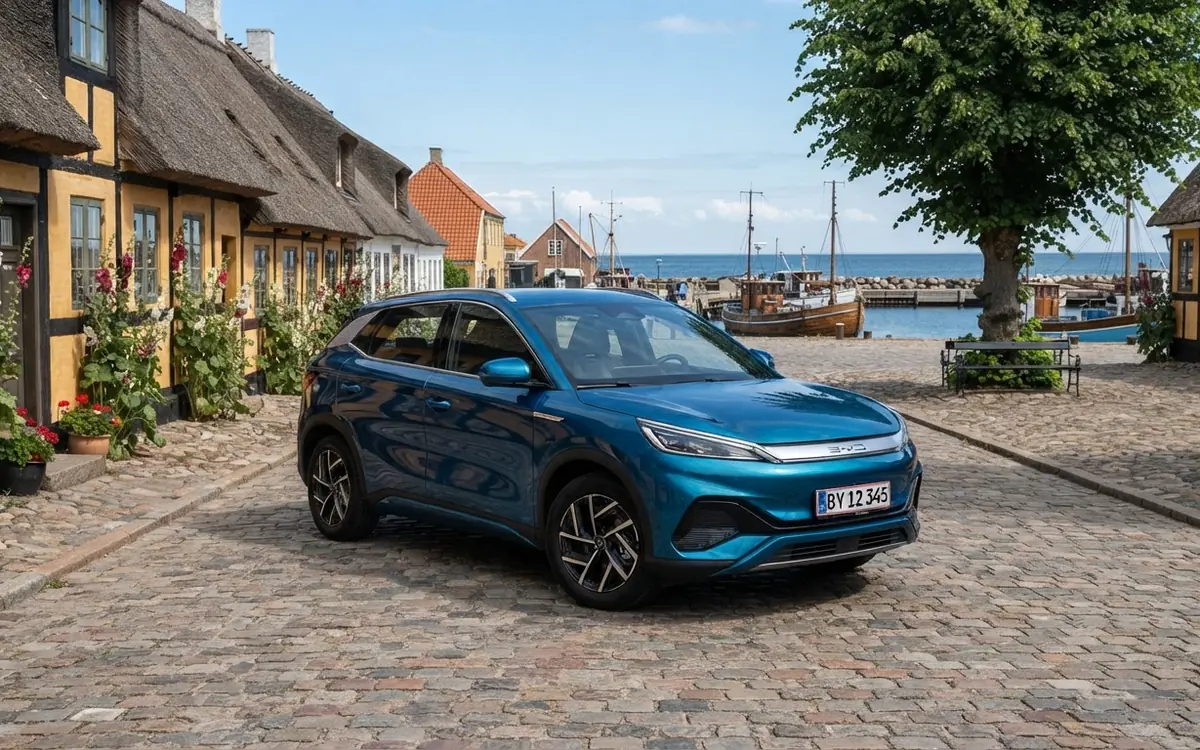 Blå BYD-elbil parkerad på en kullerstensgata i en gammal fiskeby