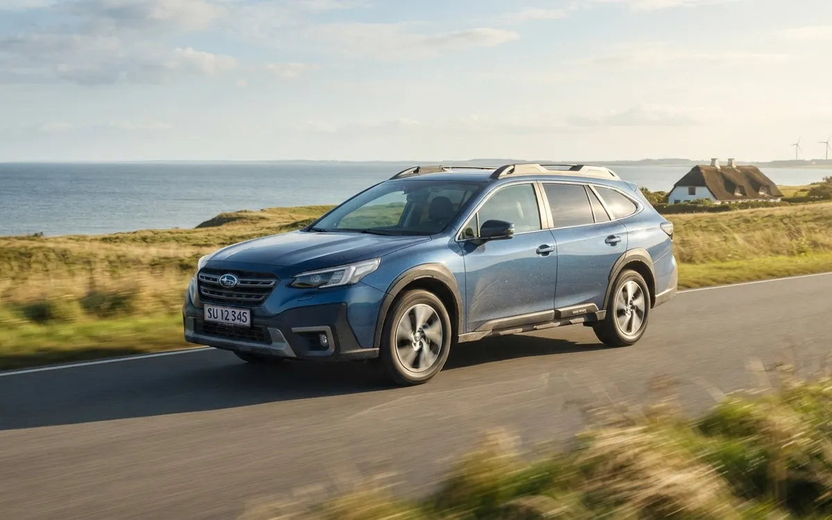 Blå Subaru Outback i rörelse på en kustväg